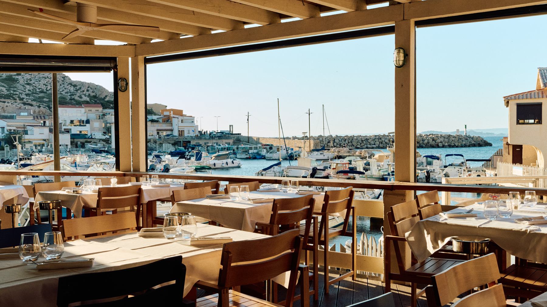 La terrasse couverte de La Marine des Goudes, tables dressées face au port