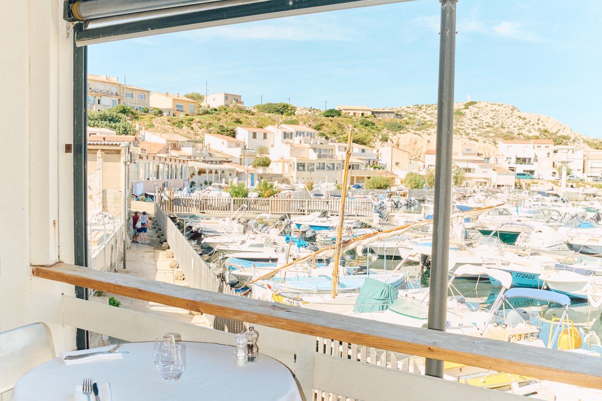 La salle vue mer, tables nappées de blanc face au port