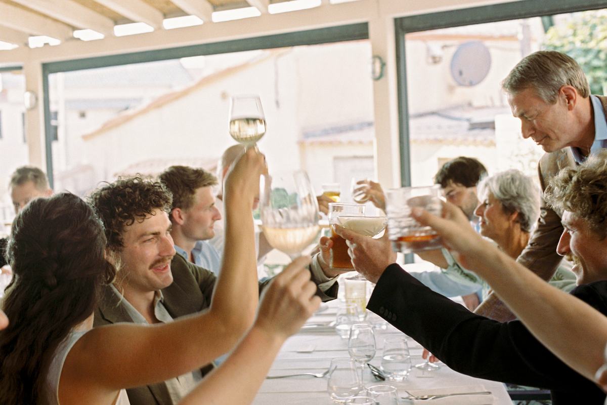 Des convives lèvent leur verre au-dessus de la table
