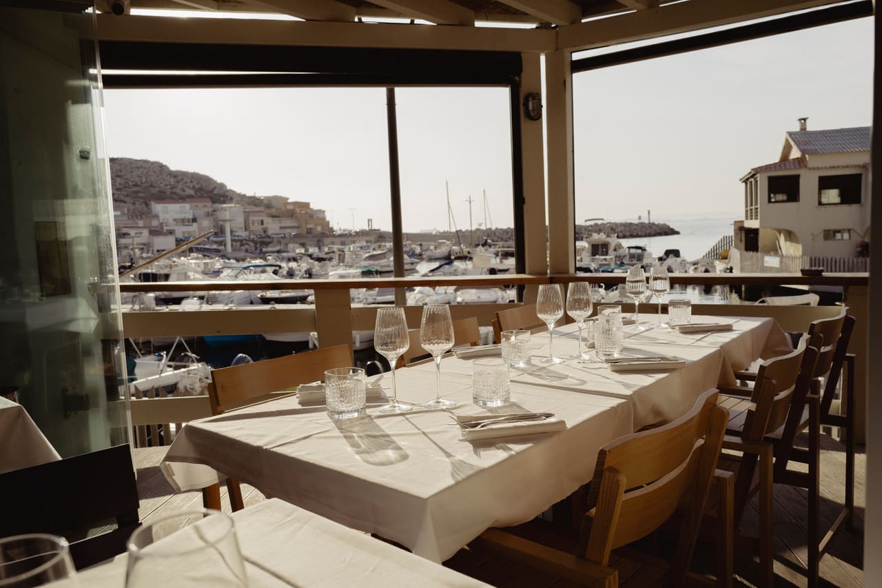 La grande tablée dressée sur la terrasse couverte, au-dessus du port des Goudes